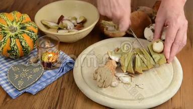 用小刀清洗小香菇做一顿饭。除了像南瓜、蜡烛和木心这样的秋天装饰。
